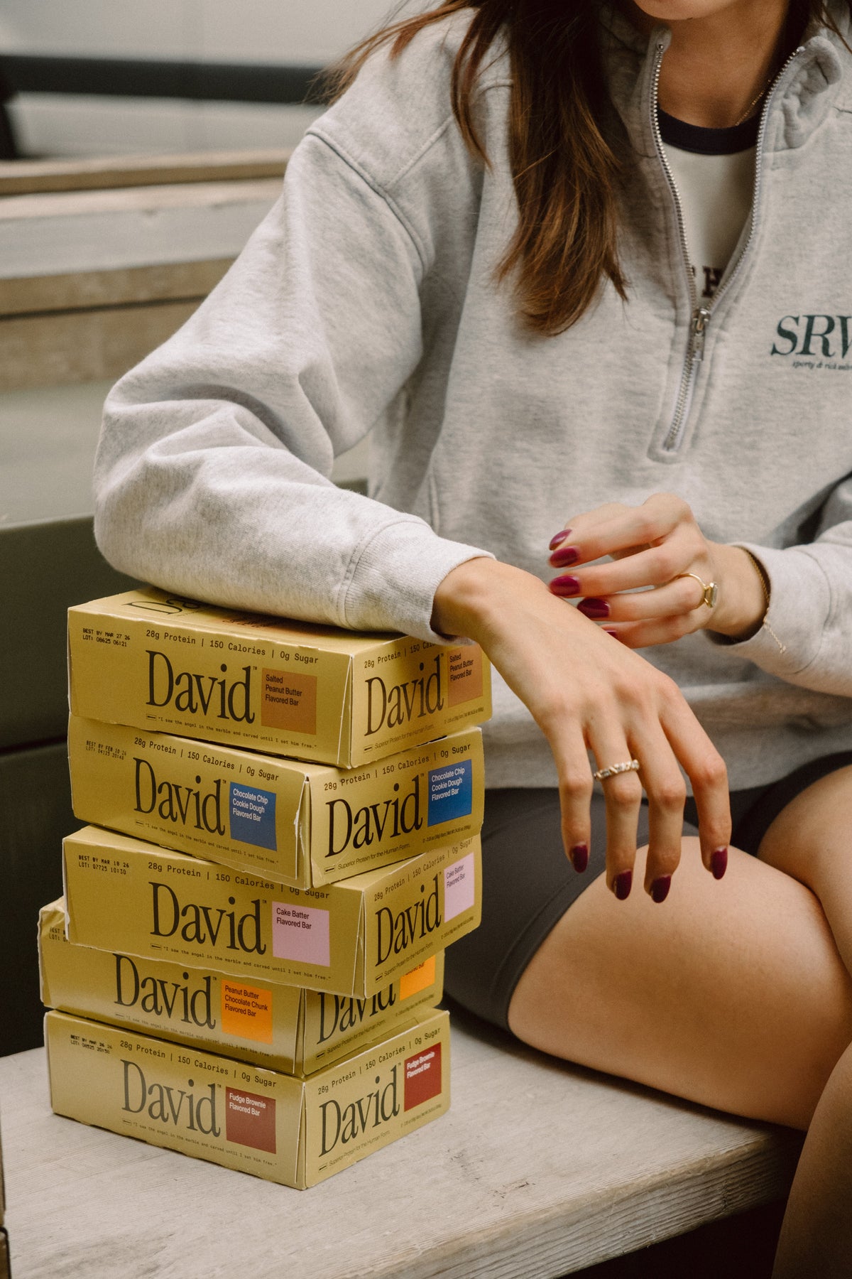 Woman with several boxes of David protein bars