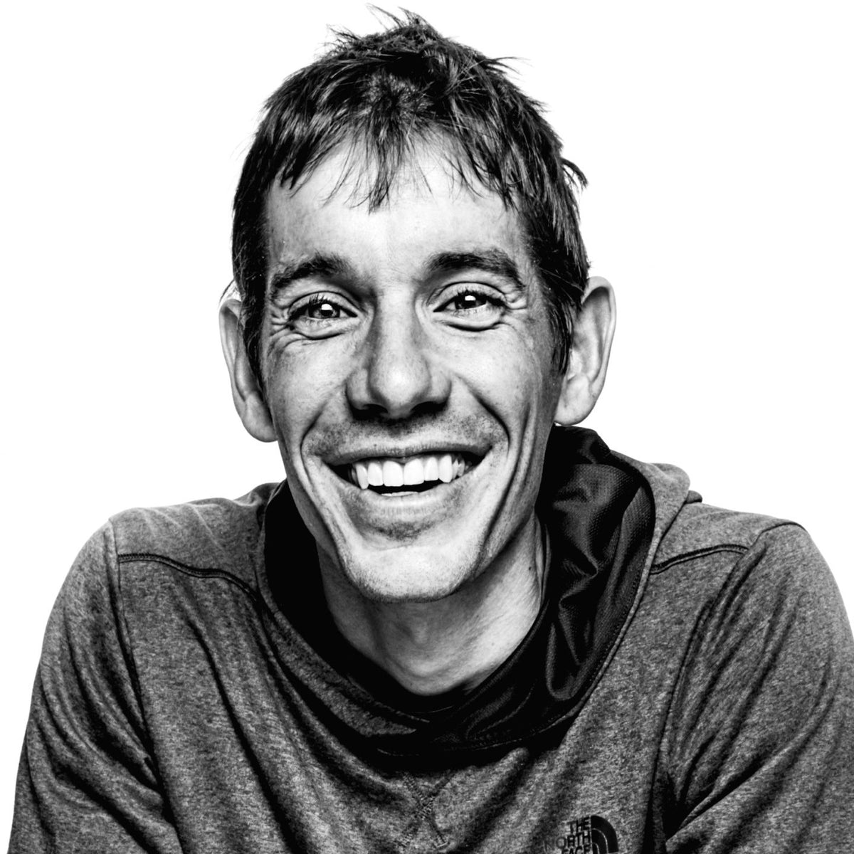 Black and white portrait of Andrew Honnold, wearing a grey hoodie