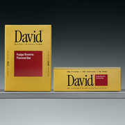 Two David Fudge Brownie Flavored Bar boxes on a shelf with a gray background