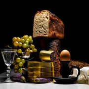 Still life with bread, grapes, and cod on a dark background