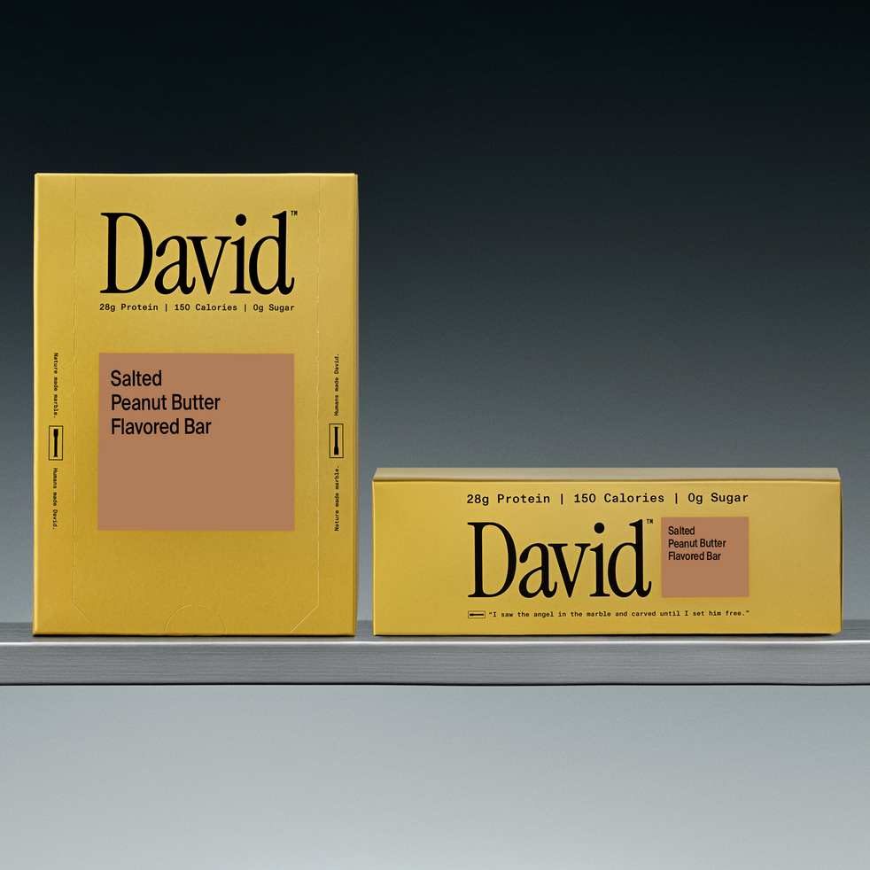 Two David salted peanut butter flavored bars on a shelf with a grey background