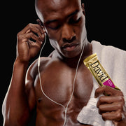 Man listening to music with earphones and holding a David protein bar.
