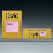 Two David cake batter flavored boxes on a gray shelf with a black background
