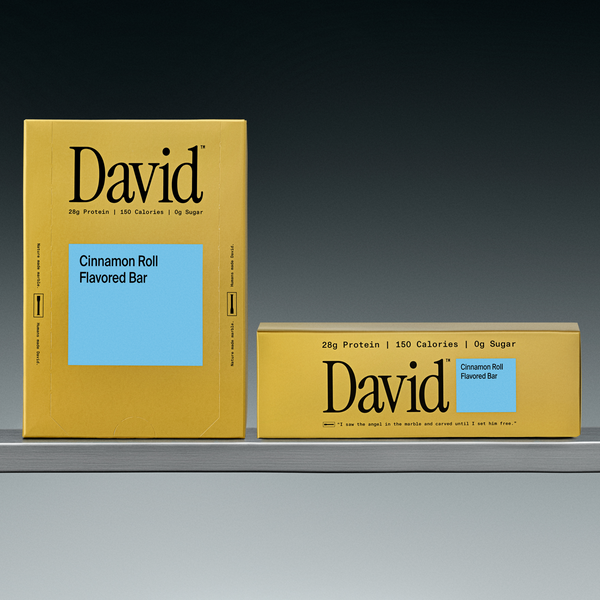Two David Cinnamon Roll Flavored Bar boxes on a gradient gray background