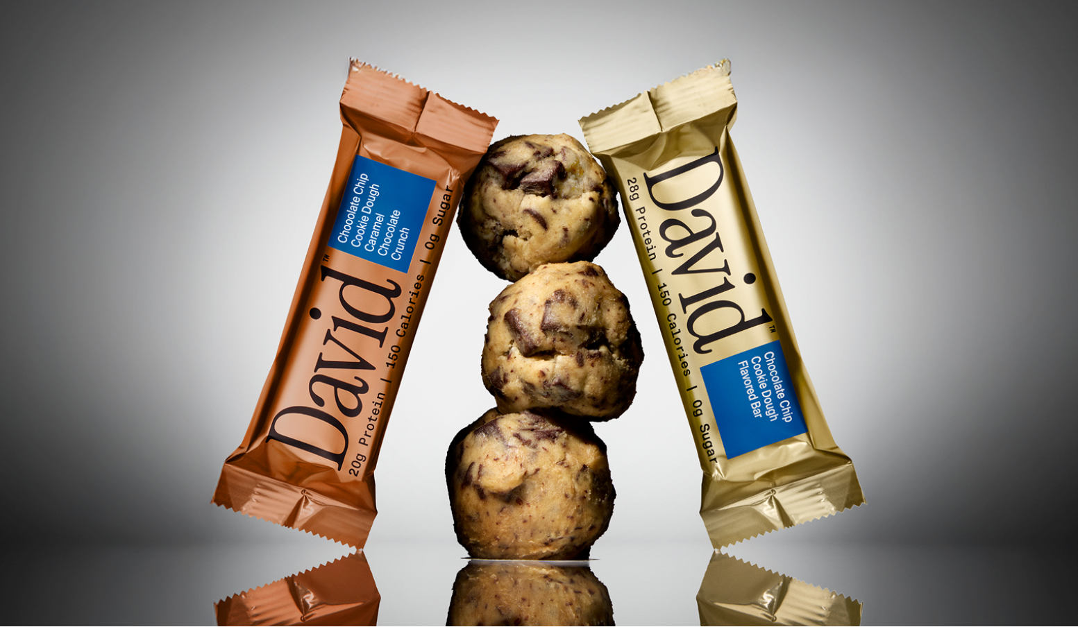 Two chocolate bars with 'David' branding on a reflective surface against a dark background