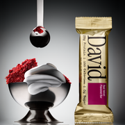 David protein bar with a bowl of red velvet cake on a gray background