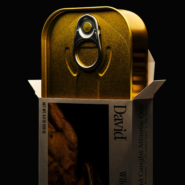 Gold canned fish with 'David' branding coming out of a box