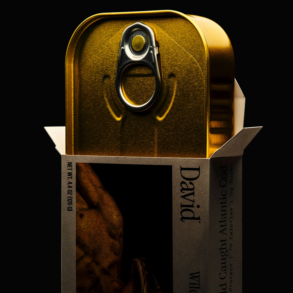 Gold canned fish with 'David' branding coming out of a box