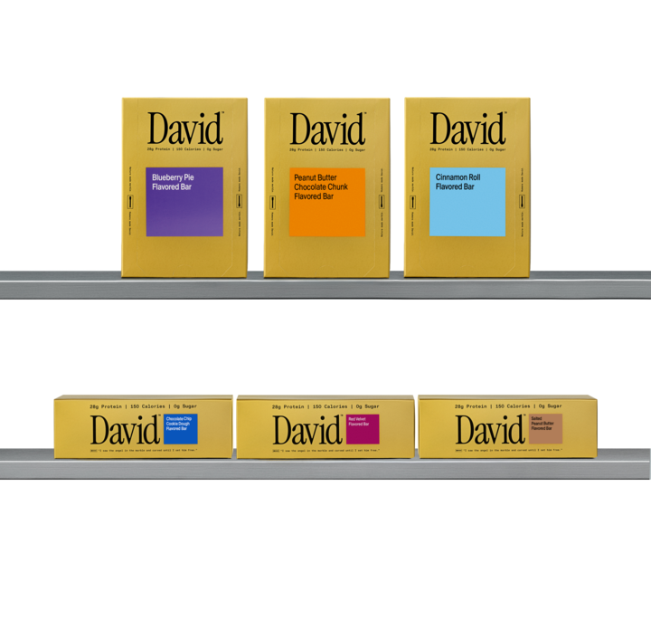 Shelf displaying various David Gold protein bar packages with different flavors.